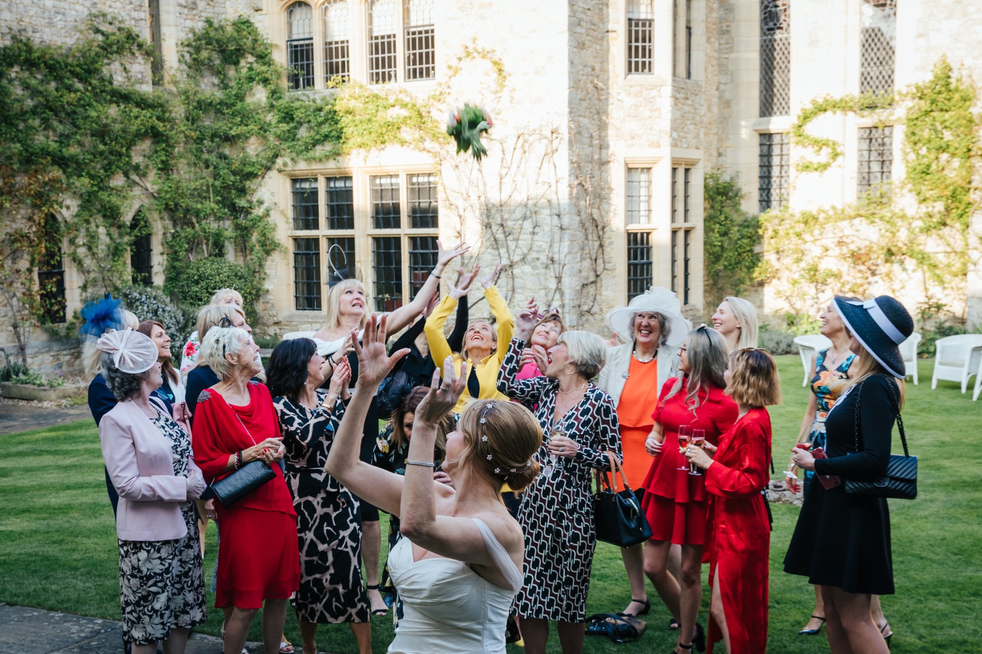 Bride throws her bouquet to her friends in the Courtyard at Allington Castle