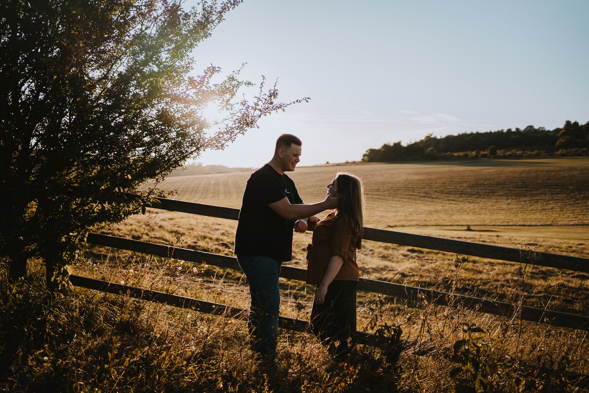 Engaged couple looking at each other during their autumnal sunset engagement shoot at Lullingstone Country Park, Kent