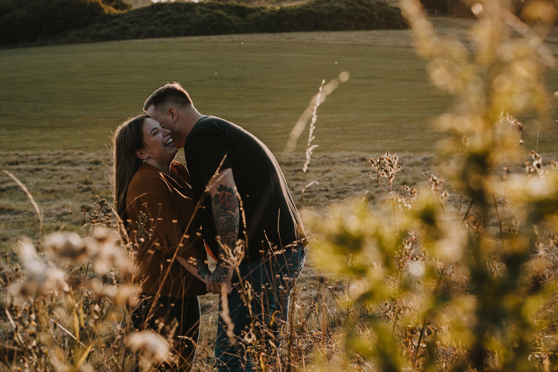 Engaged couple laughing with each other during their golden hour couple shoot at Lullingstone Country Park, Kent