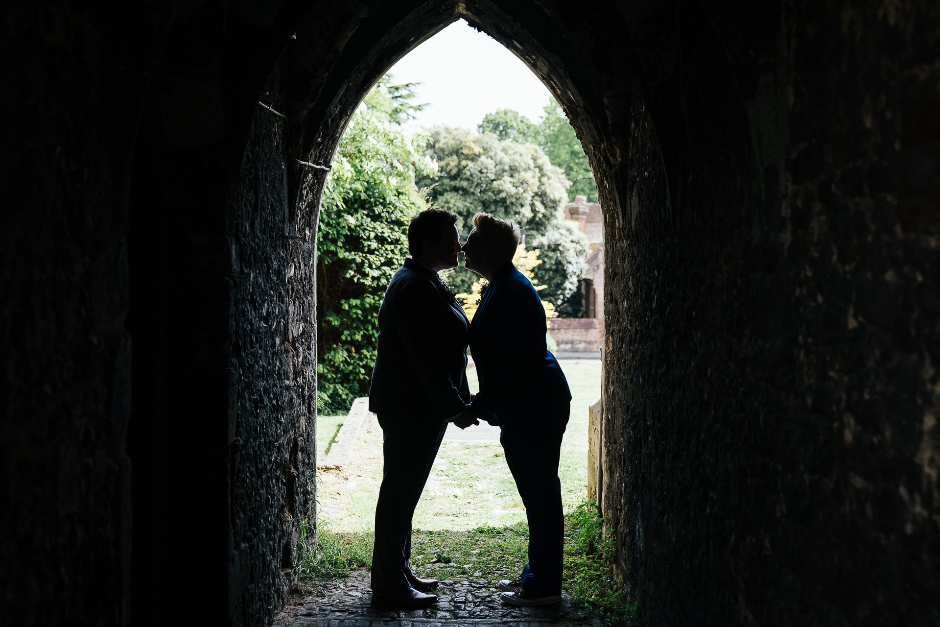 Wedding couple embrace in a tunnel after their ceremony