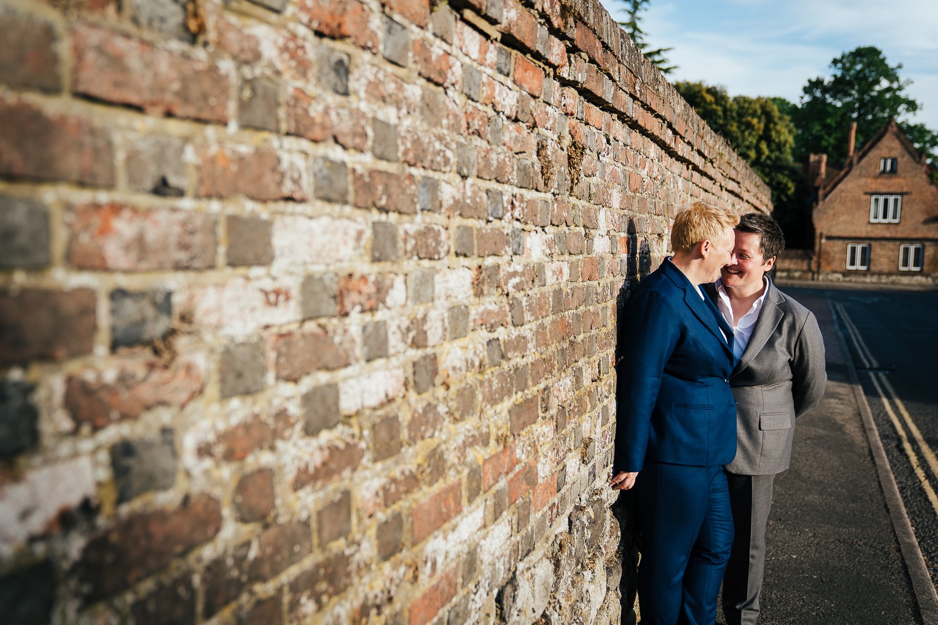 Couple embracing against wall after their wedding ceremony