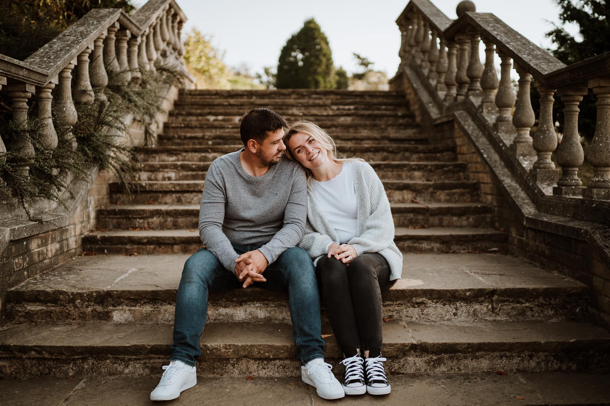 Couple sat on stone stairs during engagement shoot