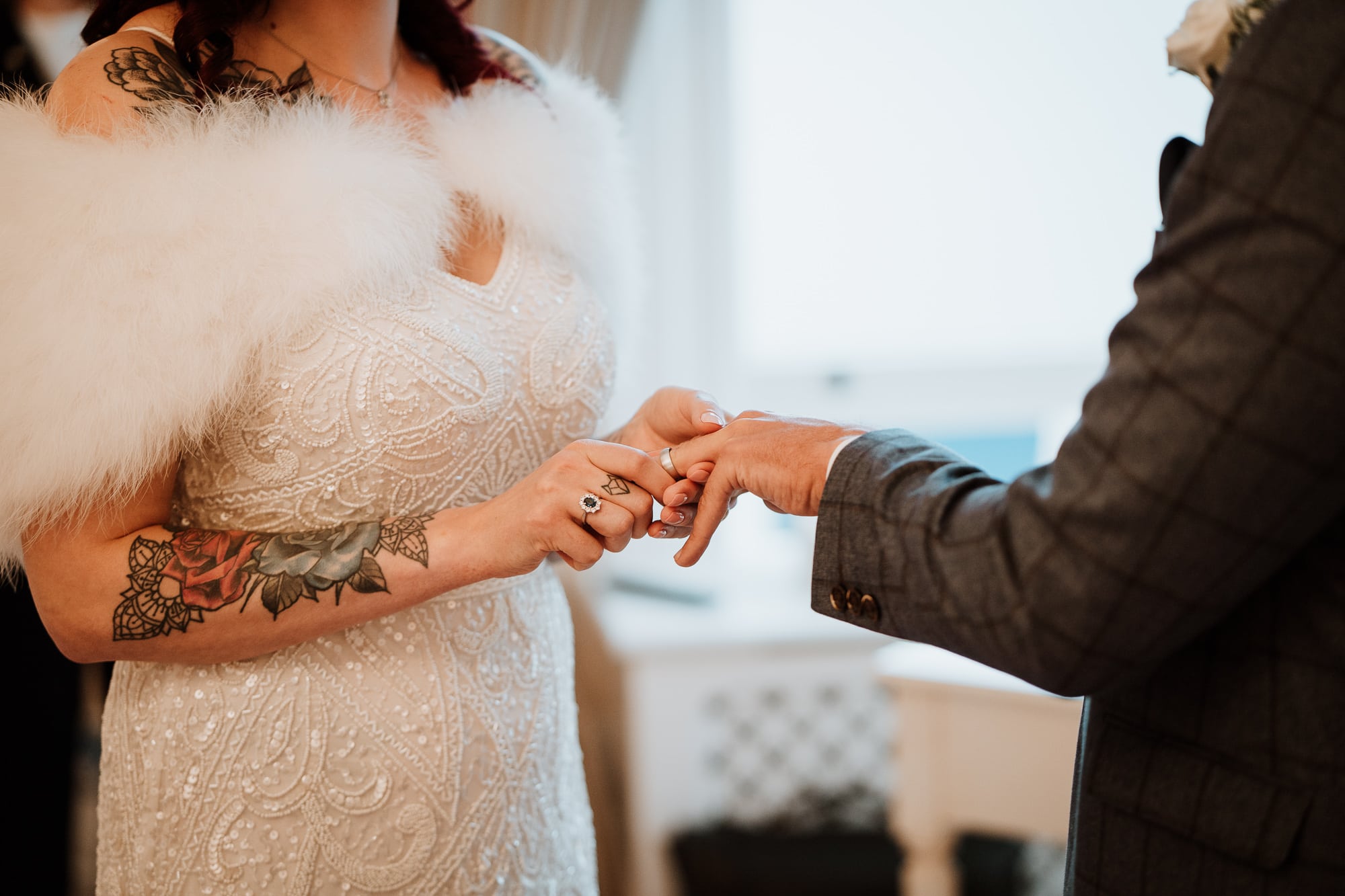 Bride placing ring on Grooms finger