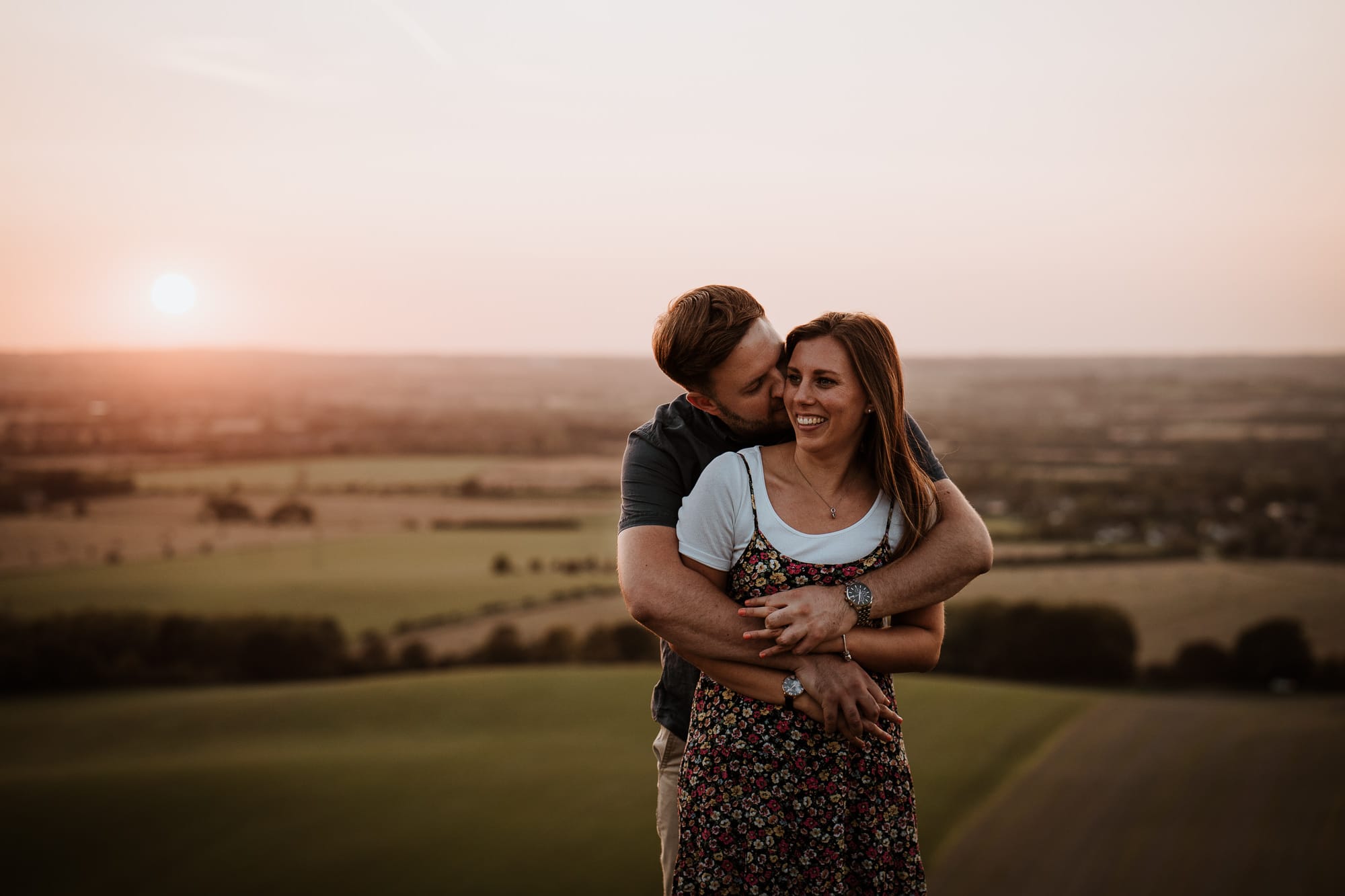 Couple holding each other on Dunstable Downs at sunset