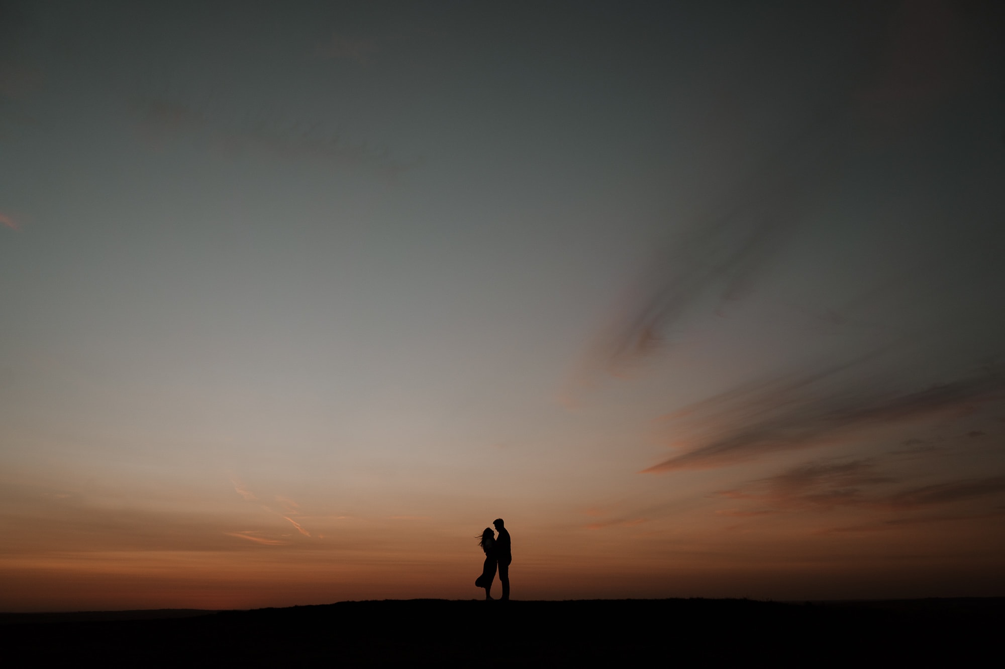 Couple hold each other after sunset