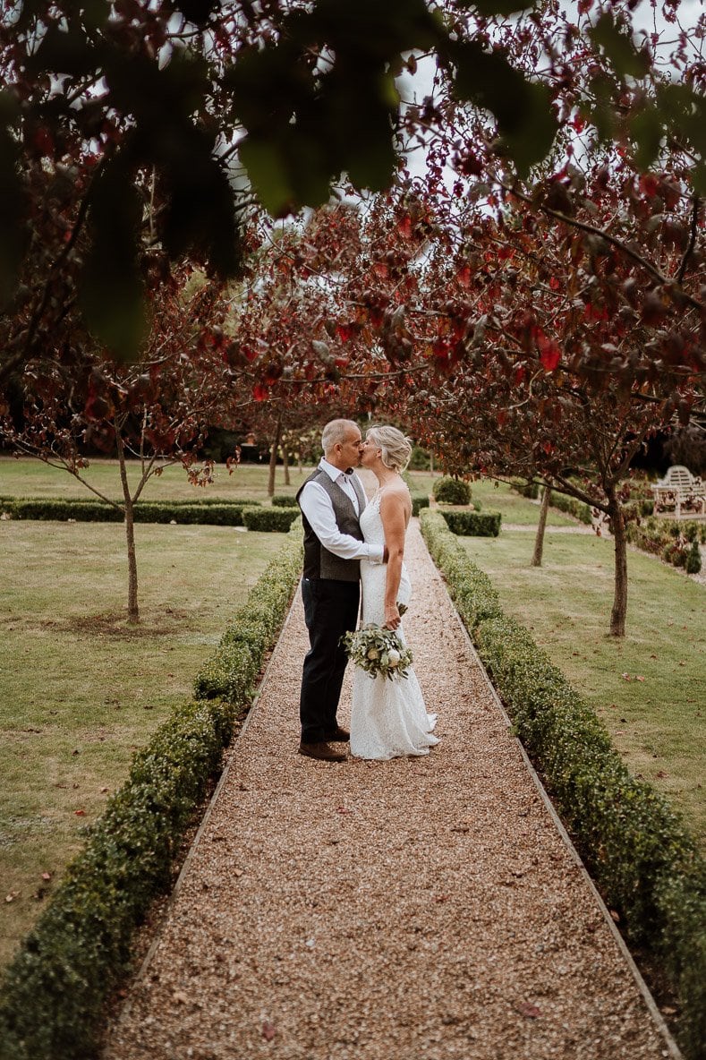 Relaxed Bride and Groom kissing in Kent secret garden