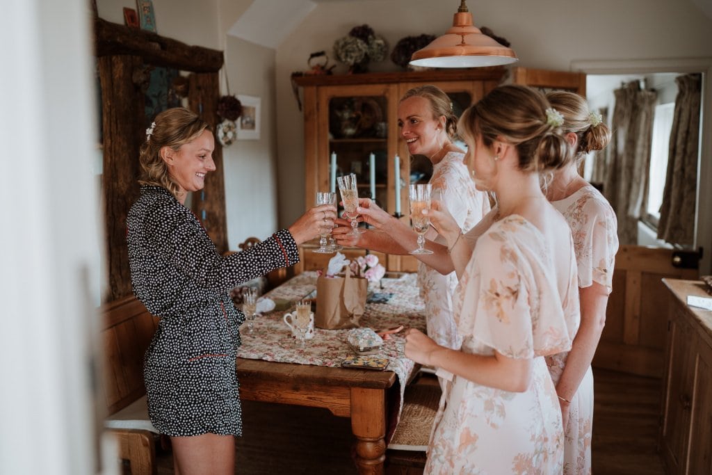 Bride raising a toast with champagne with her bridesmaids