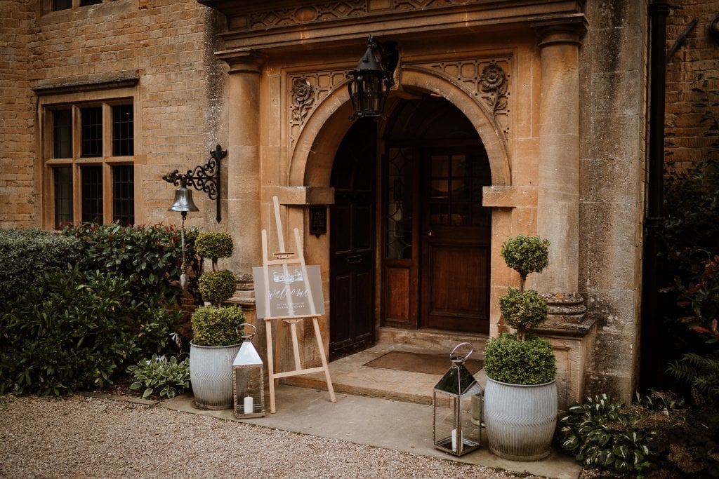 Entrance door to Foxhill Manor with stunning welcome wedding sign and candles each side