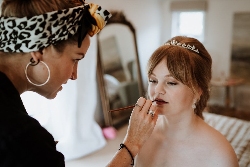 Bride having her lip stick applied during her bridal preparations