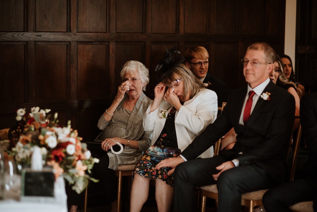 Brides Mother and Grandmother crying and dabbing their eyes during wedding ceremony