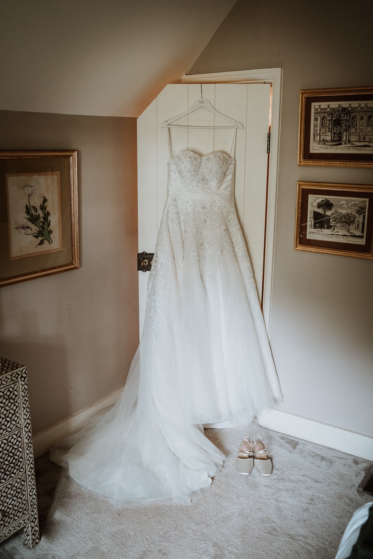 A white wedding dress hanging from the door ofthe bridal suite in Wolfe Lodge at Port Lympne in Kent