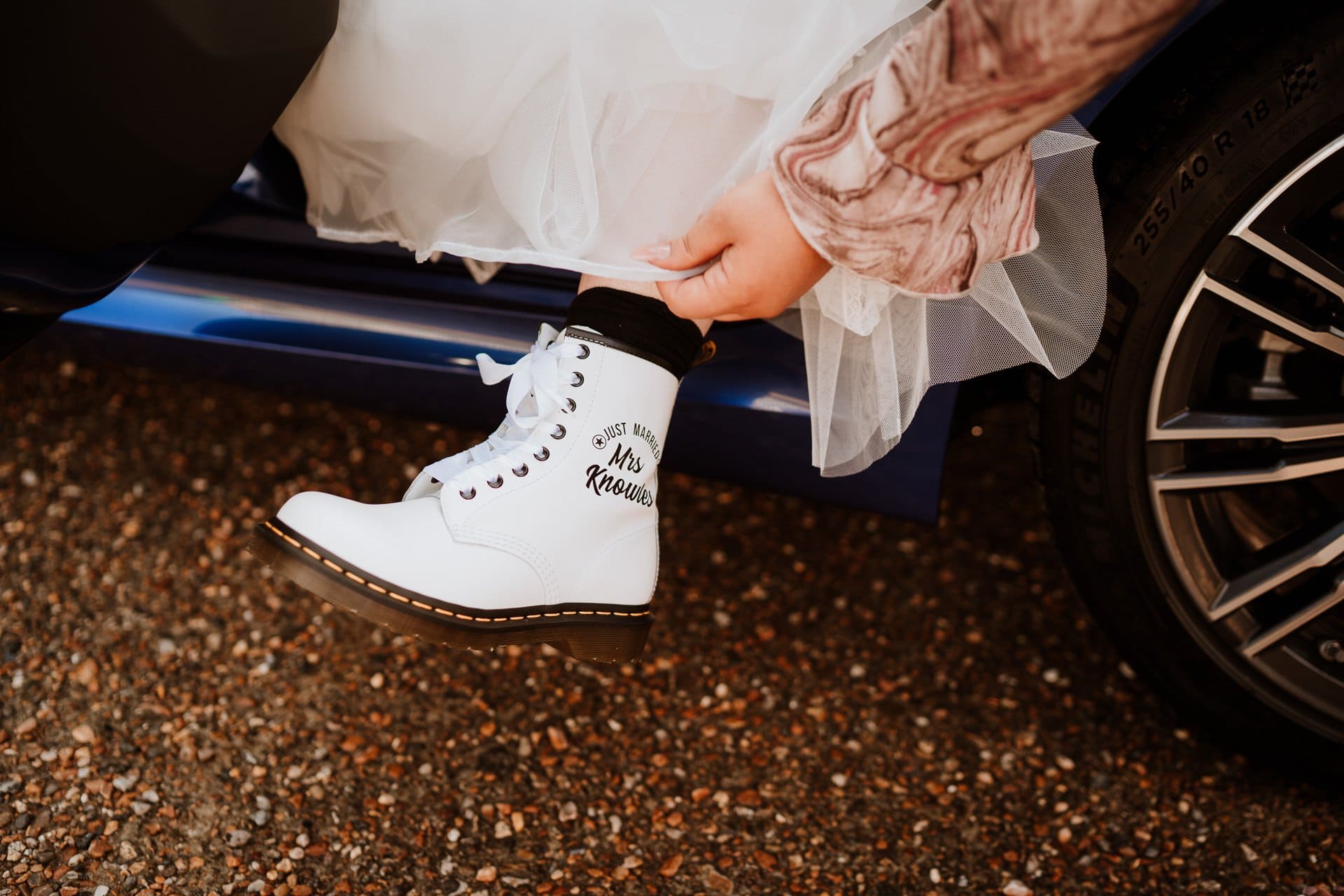 Brides foot as she exits her car wearing a white personalised Dr Marten boot