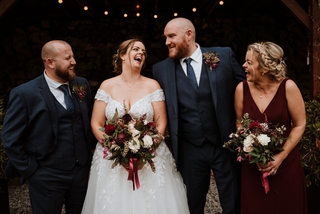 Bridal party group photograph, laughing and smiling at each other