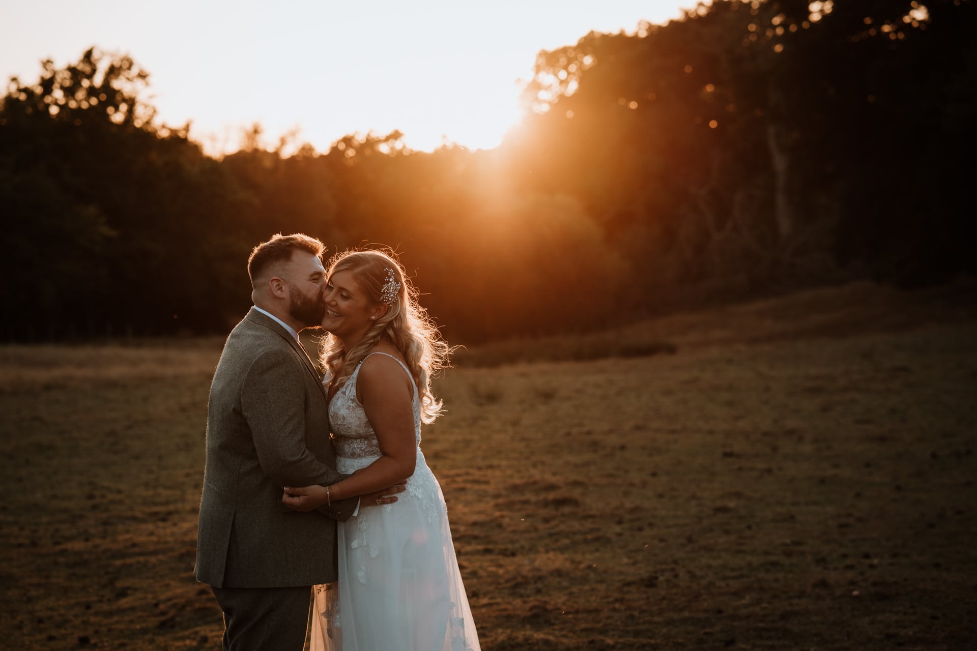 Relaxed Bride and groom kissing at sunset