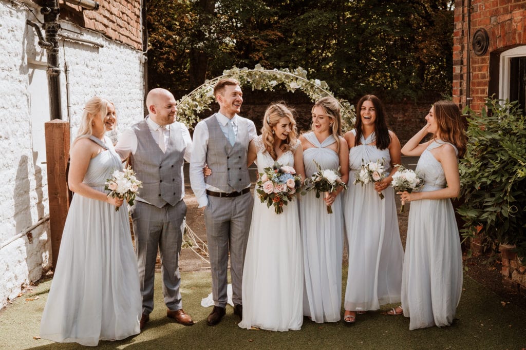 Bride and groom laughing with their bridal party at their kent wedding