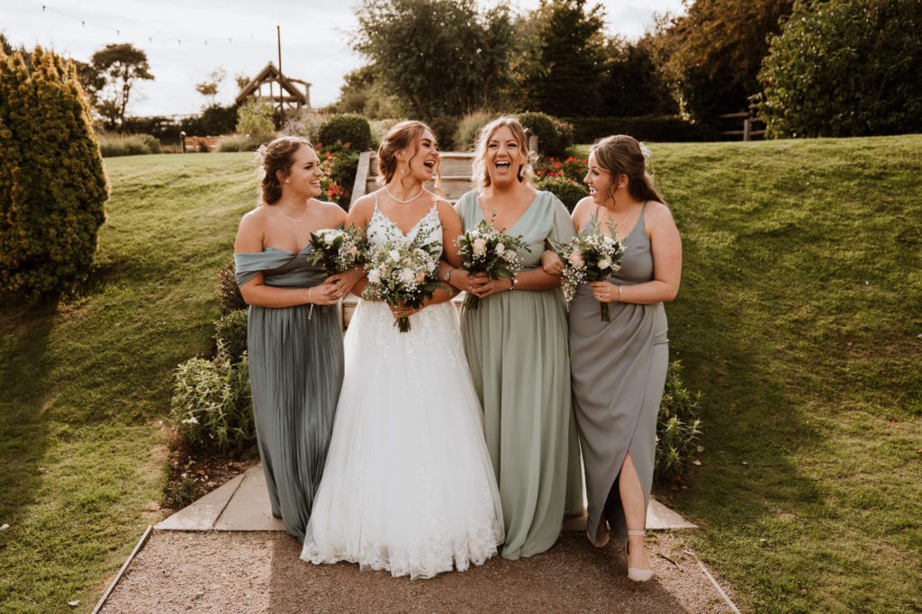 Bride and her bridesmaids laughing, relaxed and happy together in their kent wedding group shots