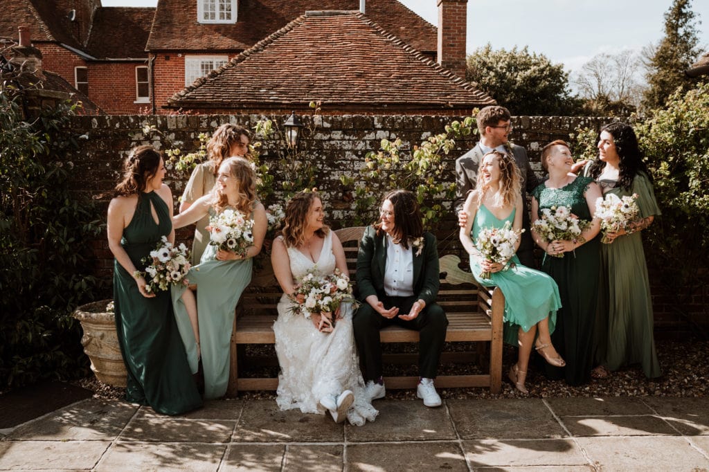 Two Brides and their bridal party in relaxed seated group shot