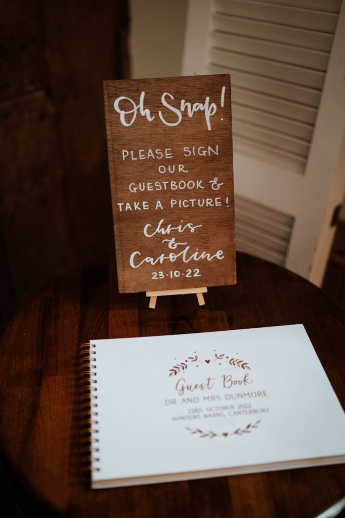 Guest book and wooden white written wedding sign