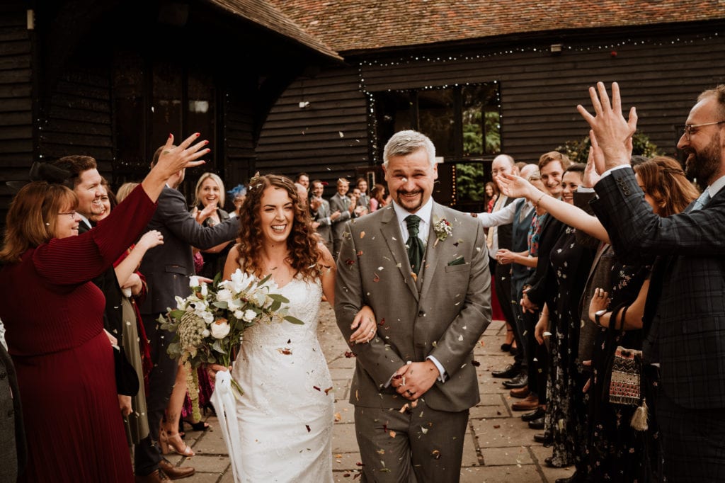 Bride and Groom showered with confetti after their wedding ceremony