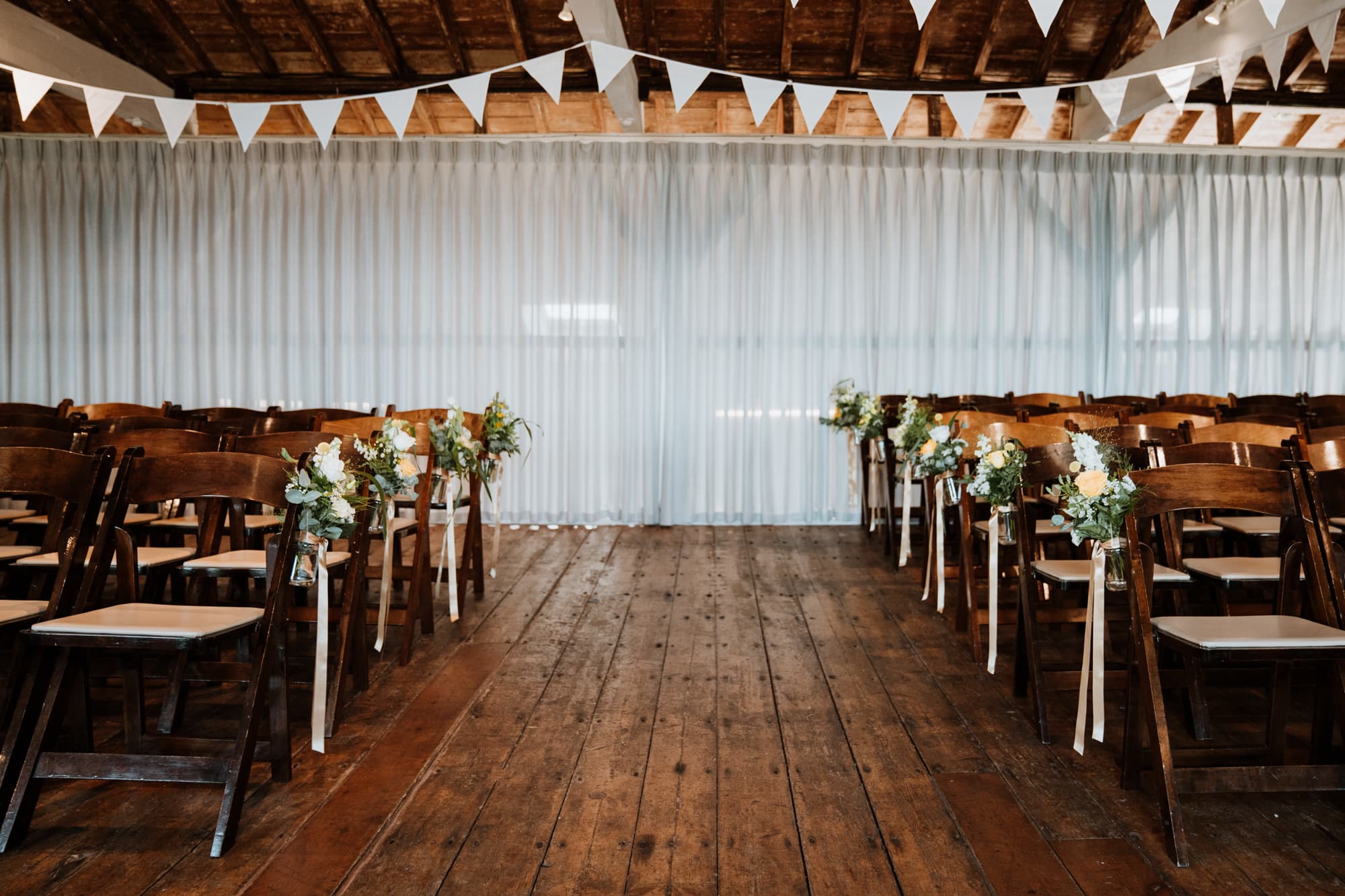 Ceremony room at East Quay with row end chairs dressed with green and yellow flowers