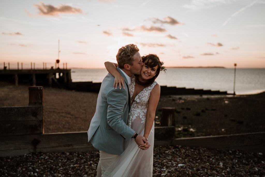 Natural wedding photography of the bride and groom on the beach during couples portraits 