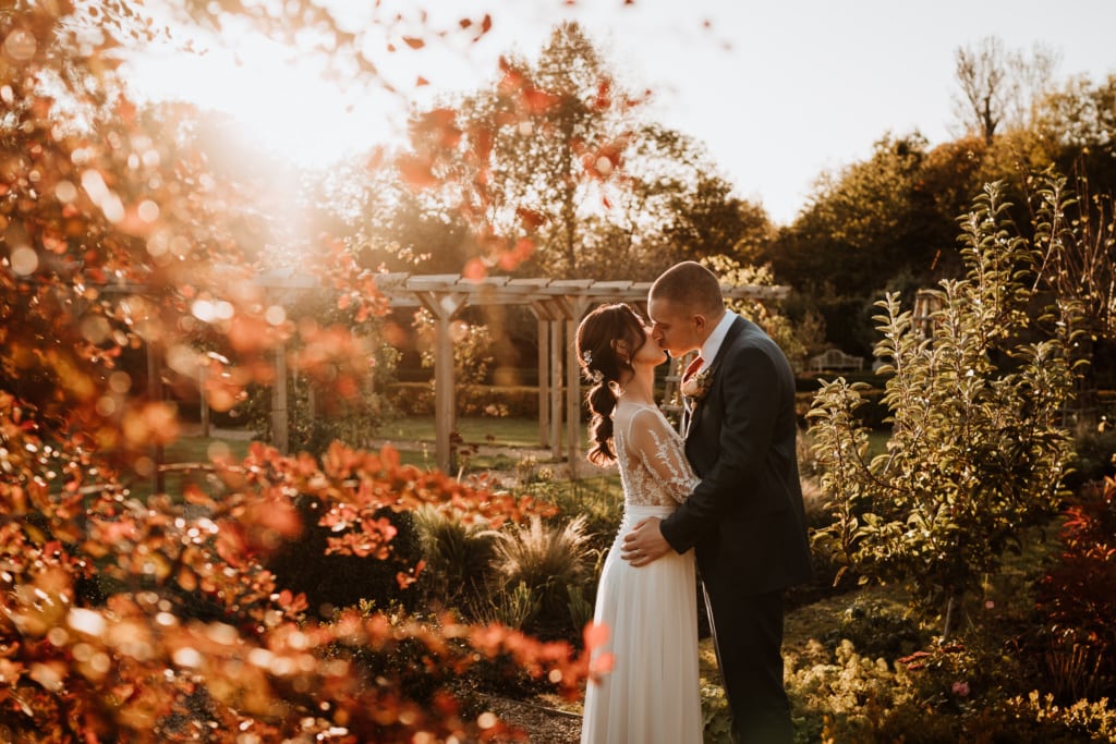 The couple kissing outside of the The Secret Garden in Ashford, Kent during their portrait shots