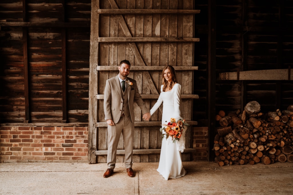 The couple standing in The Oak Barn at Frame Farm in Benenden which is a wedding venue in Kent