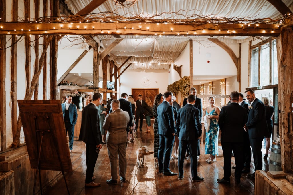A wedding reception at Winters Barn in Kent with rustic vaulted ceilings and fairy lights 